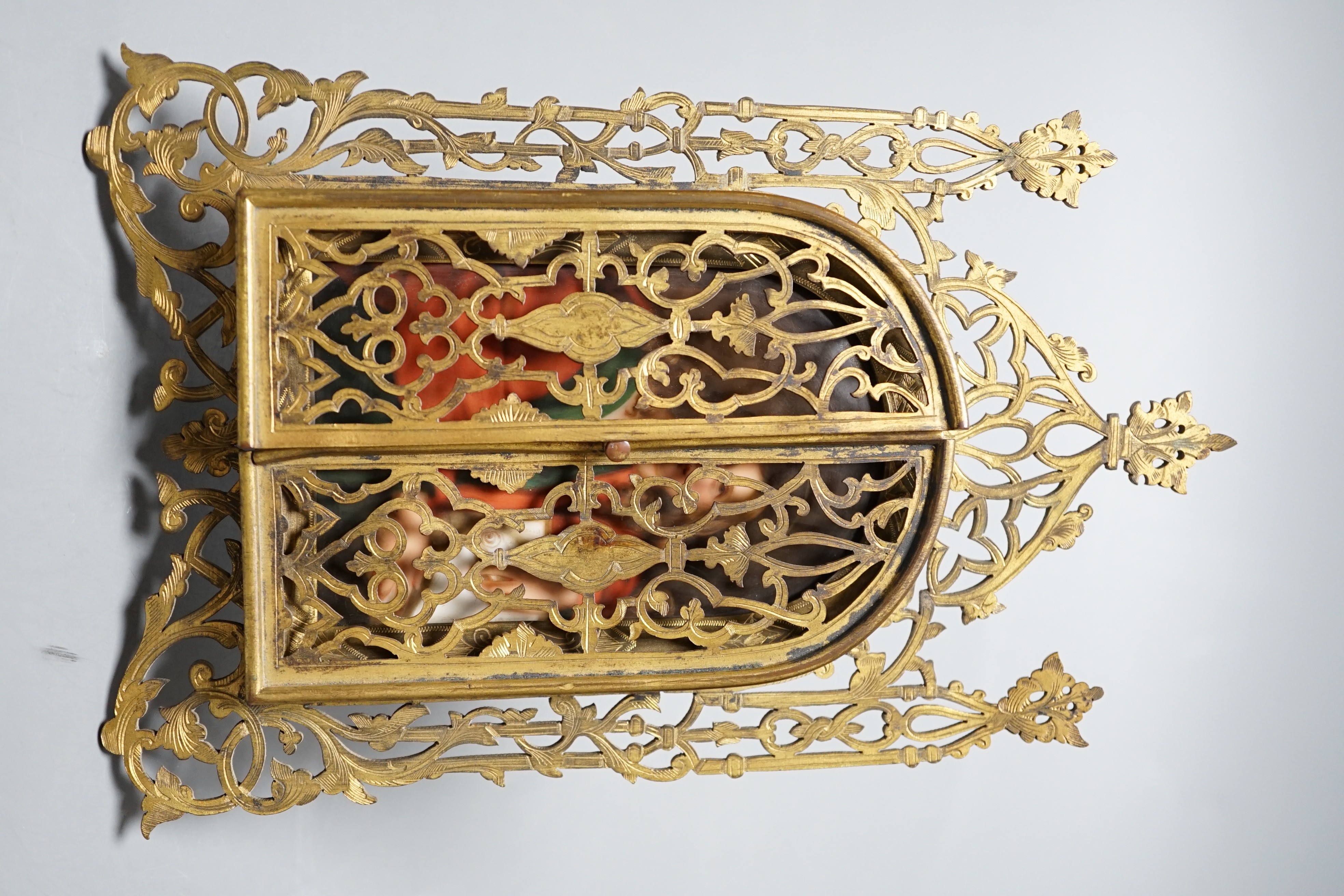 A Continental painted porcelain icon plaque in three fold pierced brass frame by Marion, London, 19cm tall